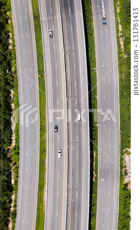 Drone shot aerial view multiple highway lanes in Thailand with few vehicles. Clean asphalt, green roadside, and minimal traffic convey efficiency and motion 131761415