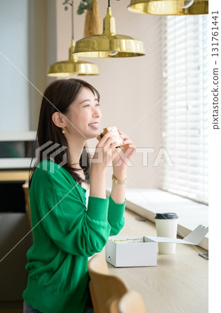 女人在一家咖啡館吃三明治 131761441