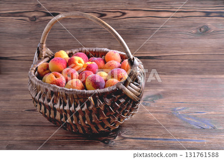 Natural ripe apricots in a wicker basket on a natural wooden background, copy space Natural ripe apricots in a wicker basket on a natural wooden background, copy space 131761588