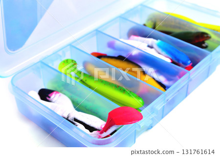 Box for fishing accessories with silicone baits inside on a white background close-up Box for fishing accessories with silicone baits inside on a white background close-up 131761614