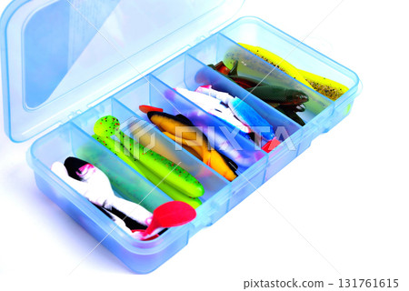 Box for fishing accessories with silicone baits inside on a white background close-up Box for fishing accessories with silicone baits inside on a white background close-up 131761615