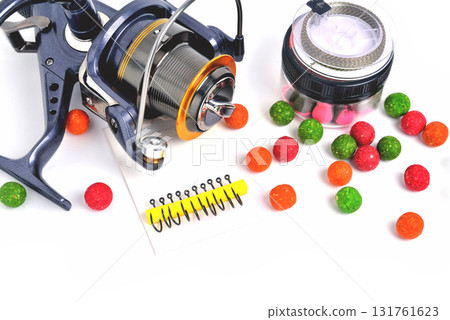 Fishing coil, carp hooks colored boilies, braided cord, on white background, close-up Fishing coil, carp hooks colored boilies, braided cord, on white background, close-up 131761623