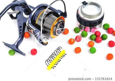 Fishing coil, colored boilies, braided cord, on white background, close-up Fishing coil, colored boilies, braided cord, on white background, close-up 131761624