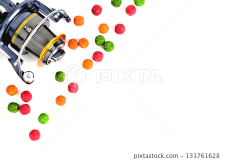 Fishing coil, colored boilies, braided cord, on white background, close-up 131761628