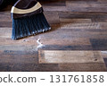 Close-up of a broom sweeping dust and dirt on a wooden floor 131761858