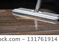 Close-up of a mop cleaning a wooden floor with water and detergent 131761914