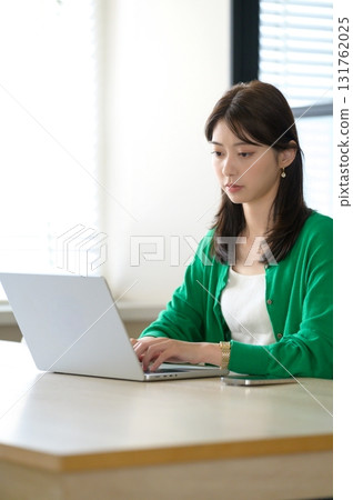 一位身著辦公室休閒服的女士在筆記型電腦上工作 一位身著辦公室休閒服的女士在筆記型電腦上工作 131762025