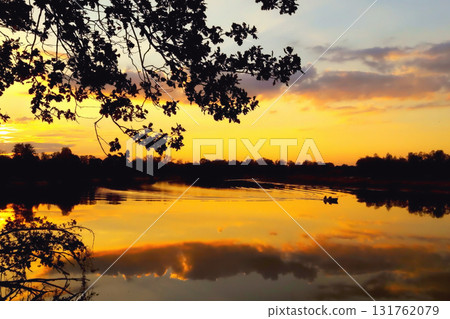Evening, sunset, river, reflection of clouds in the water, boat with fisherman Evening, sunset, river, reflection of clouds in the water, boat with fisherman 131762079