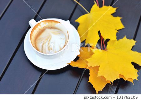 Unfinished coffee, yellow leaves, wooden table, autumn mood, close-up Unfinished coffee, yellow leaves, wooden table, autumn mood, close-up 131762109