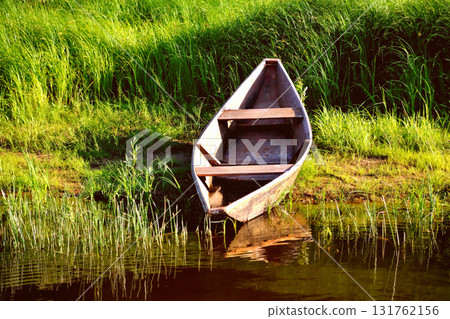 Old wooden boat on the shore, green sedge sunny day toning Old wooden boat on the shore, green sedge sunny day toning 131762156