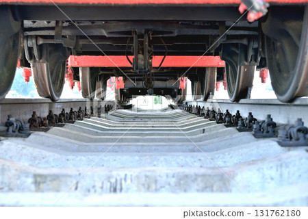 Old railway locomotive, bottom view, standing on rails, 131762180