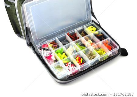 A box with a variety of silicone baits lies in a fishing bag, white background close-up A box with a variety of silicone baits lies in a fishing bag, white background close-up 131762193