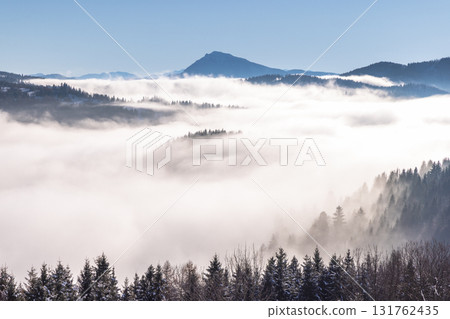 Snowy winter landscape in a misty sunny morning. The Orava region in north of Slovakia, Europe. Snowy winter landscape in a misty sunny morning. The Orava region in north of Slovakia, Europe. 131762435