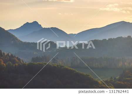 A serene landscape of rolling mountains fading into the horizon, bathed in soft, warm light, creating a peaceful and majestic scene. View of The Mala Fatra national park in Slovakia, Europe. A serene landscape of rolling mountains fading into the horizon, bathed in soft, warm light, creating a peaceful and majestic scene. View of The Mala Fatra national park in Slovakia, Europe. 131762441