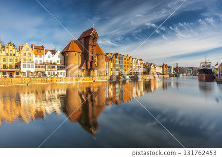 Gdansk with medieval port crane over The Motlawa river, a city on the Baltic coast of northern Poland, Europe. Waterfront cityscape view of a historical city with reflection on the water surface. 131762453
