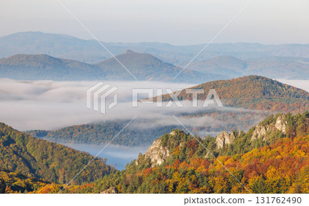 Autumn mountains landscape with colorful foliage, trees, forest hills and fog shrouded valleys in scenic rural area aerial view. The Sulov Rocks, national nature reserve in Slovakia, Europe. Autumn mountains landscape with colorful foliage, trees, forest hills and fog shrouded valleys in scenic rural area aerial view. The Sulov Rocks, national nature reserve in Slovakia, Europe. 131762490