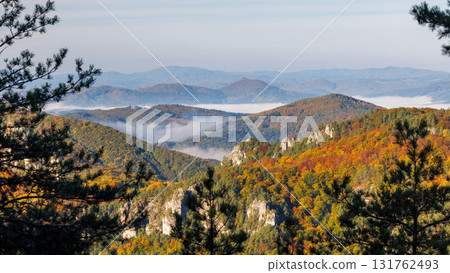 Autumnal mountain view with colorful foliage, layered ridges, and a touch of mist enhancing the scenic vista. The Sulov Rocks, national nature reserve in northwest of Slovakia, Europe. 131762493