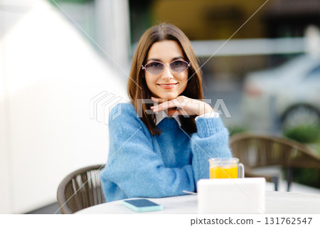 Young woman enjoying a relaxing moment at outdoor cafe Young woman enjoying a relaxing moment at outdoor cafe 131762547