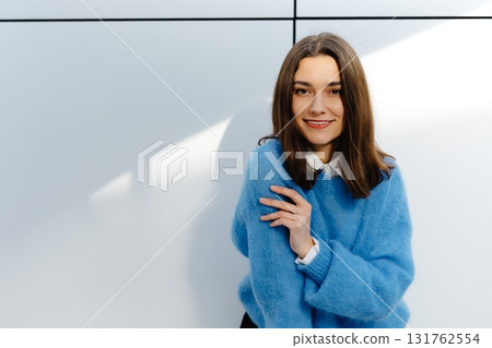 Confident Young Woman in Blue Sweater Smiling Brightly Confident Young Woman in Blue Sweater Smiling Brightly 131762554