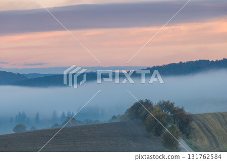 Misty Sunrise Landscape with Hills and Valley, a serene and atmospheric view of nature's beauty Misty Sunrise Landscape with Hills and Valley, a serene and atmospheric view of nature's beauty 131762584