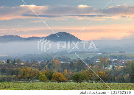 Scenic autumn landscape with misty hills and a charming village, evoking tranquility and natural beauty. Scenic autumn landscape with misty hills and a charming village, evoking tranquility and natural beauty. 131762589