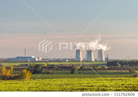Energy landscape: Nuclear plant amidst sprawling green fields, contributing to power generation. 131762600