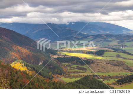 Panoramic view of a valley landscape under a cloudy sky. Mountains are in the distance. The Liptov region in Slovakia, Europe. Panoramic view of a valley landscape under a cloudy sky. Mountains are in the distance. The Liptov region in Slovakia, Europe. 131762619
