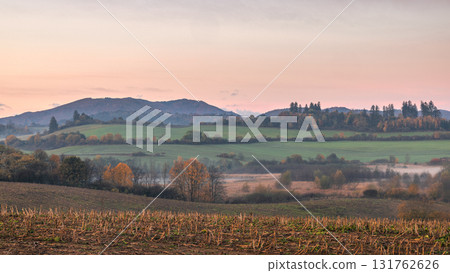 Rolling hills and autumn fields under a pastel sky, creating a serene countryside landscape. Rolling hills and autumn fields under a pastel sky, creating a serene countryside landscape. 131762626