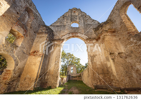 The Katarinka, ruins of a Franciscan monastery and church in Slovakia, Europe. Old church ruins stand against a bright blue sky, stone walls and archway framing the view beyond. The Katarinka, ruins of a Franciscan monastery and church in Slovakia, Europe. Old church ruins stand against a bright blue sky, stone walls and archway framing the view beyond. 131762636
