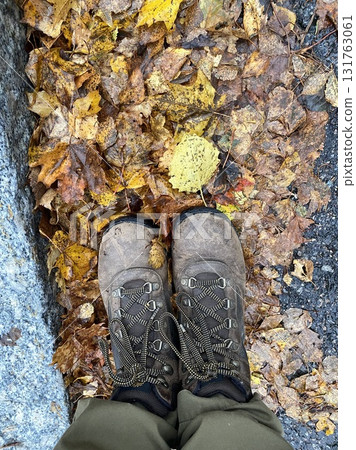 Hiking boots standing on wet autumn leaves on forest path Hiking boots standing on wet autumn leaves on forest path 131763061