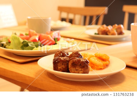 A cozy table setting featuring fragrant meatballs and shrimp with a colorful salad A cozy table setting featuring fragrant meatballs and shrimp with a colorful salad 131763238