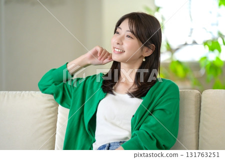 Woman sitting on the sofa and relaxing Woman sitting on the sofa and relaxing 131763251