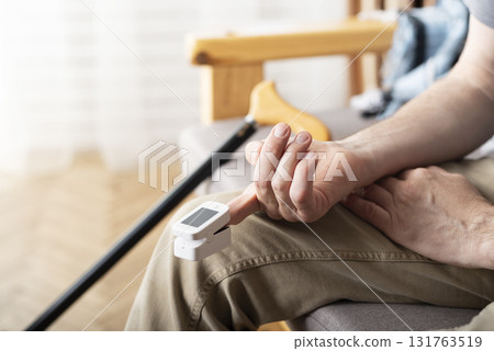Caucasian middle aged man using pulse oximeter at home 131763519