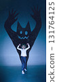 Creative digital artwork. Little girl acting playfully with monster shadow silhouette on blue background 131764125