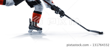 Close-up of hockey skates, stick, and puck. Hockey isolated. Hockey player on the rink at high speed. Focus on the puck. Hockey. Hockey player in action 131764332