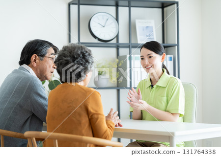 Caregiver explaining to senior couple 131764338