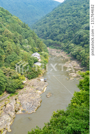 View of the Oi River (Hozu River) and the Arashiyama mountain range from the observation deck at the top of the Kameyama area of Arashiyama Park (commonly known as Kameyama Park), Kyoto 131764682