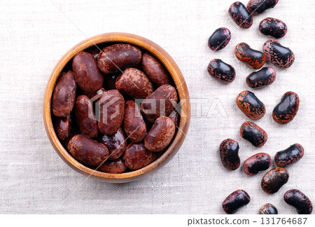 Cooked scarlet runner beans in, a wooden bowl, on linen. Boiled runner beans, seeds of Phaseolus coccineus, also known as multiflora or butter bean. In Austria they are called beetle-beans. Food photo Cooked scarlet runner beans in, a wooden bowl, on linen. Boiled runner beans, seeds of Phaseolus coccineus, also known as multiflora or butter bean. In Austria they are called beetle-beans. Food photo 131764687