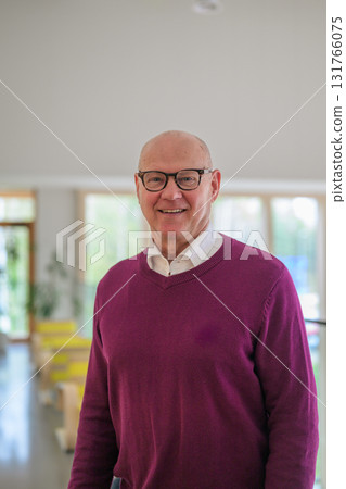 Portrait of a happy senior man with glasses in a corridor at home 131766075