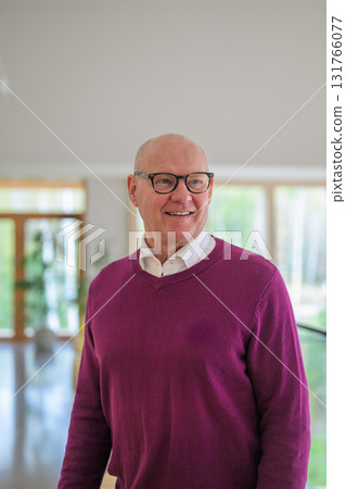 Portrait of smiling senior man with eyeglasses in living room at home 131766077