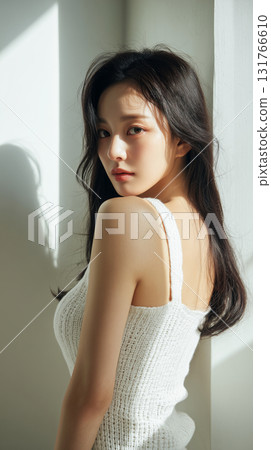 Asian woman with long hair poses by sunlight in a minimalist indoor setting, showcasing natural beauty and elegance 131766610