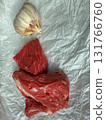 Raw beef cuts with garlic on crumpled parchment, top view cooking ingredients 131766760