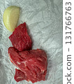 Raw beef cuts with onion slice on white parchment paper - fresh red meat food background, culinary ingredient closeup 131766763