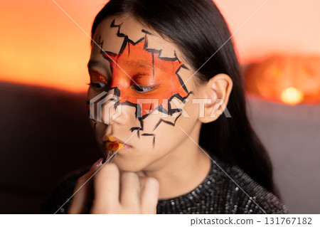 girl with face paint in a colorful design,smiling happily at a summer carnival girl with face paint in a colorful design,smiling happily at a summer carnival 131767182