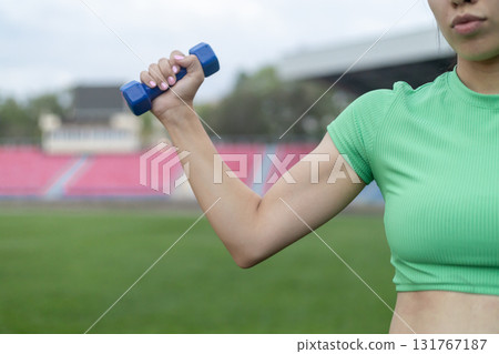 A woman is exercising with a dumbbell 131767187
