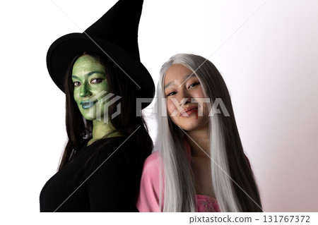 The two women are posing for a picture for Halloween party. 131767372