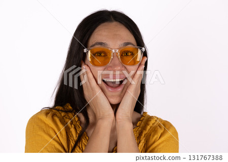 A woman is holding her face with a surprised expression 131767388