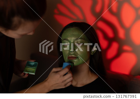 girl's makeup artist applies makeup inspired by scary hero for Halloween party girl's makeup artist applies makeup inspired by scary hero for Halloween party 131767391