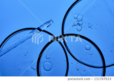 The texture of the serum with PDRN in a petri dish on a blue background. The texture of the serum with PDRN in a petri dish on a blue background. 131767614
