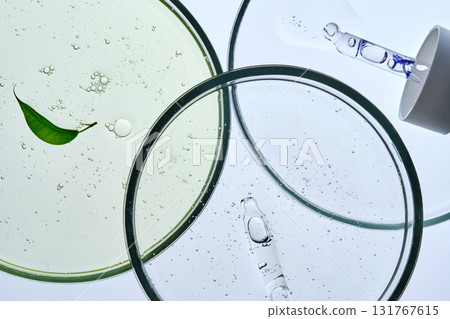 Three petri dishes with different serums and pipettes. Three petri dishes with different serums and pipettes. 131767615